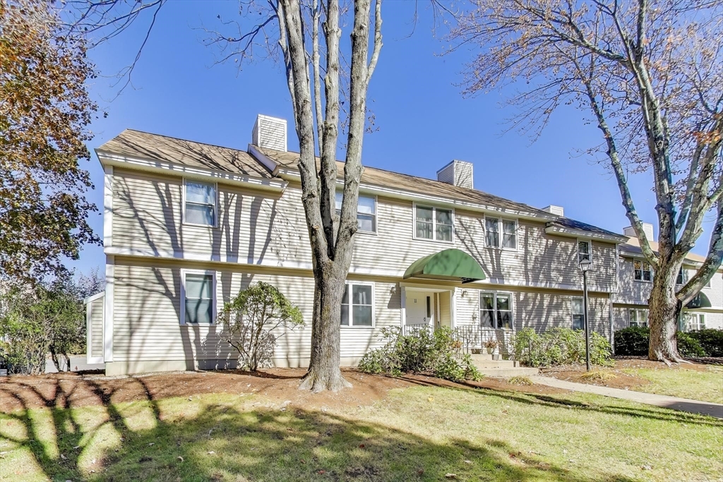 425 Main Street, Unit 11B Hudson, MA 01749 - Photo 2 of 26 a front view of a house with a yard table and chairs