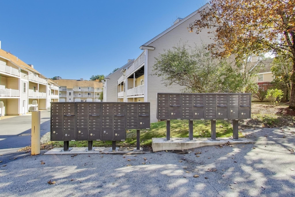 425 Main Street, Unit 11B Hudson, MA 01749 - Photo 24 of 26 a view of a brick house with a yard and large tree