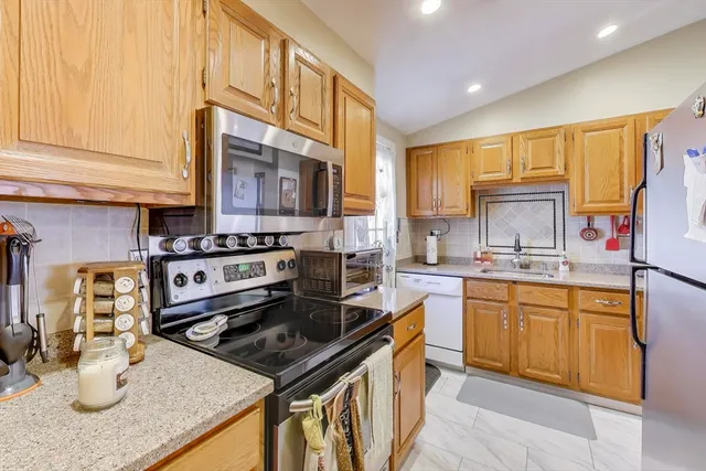 a kitchen with stainless steel appliances granite countertop a sink stove and cabinets