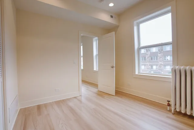 a view of empty room with wooden floor