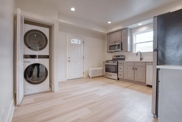 a kitchen with white cabinets stainless steel appliances and a window