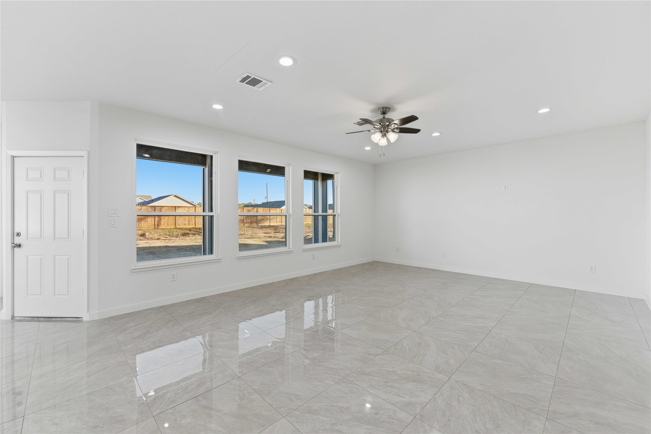 18611 Ratho Drive Conroe, TX 77306 - Photo 9 of 28 an empty room with windows and chandelier fan