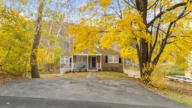 front view of a house with a yard and an trees