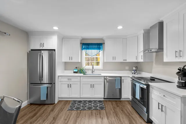 a kitchen with a sink wooden floor and stainless steel appliances