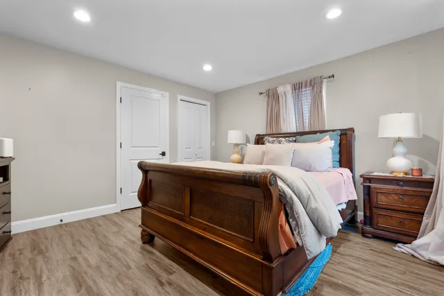 a bedroom with a bed and wooden floor