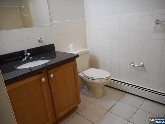 a bathroom with a granite countertop sink a toilet and a mirror