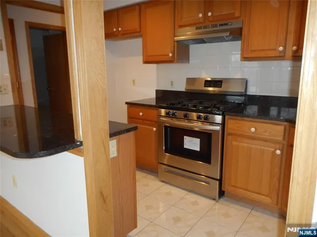 a kitchen with stainless steel appliances granite countertop a stove and a refrigerator
