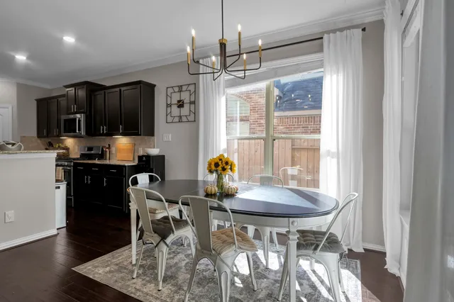 a kitchen with stainless steel appliances granite countertop wooden cabinets a refrigerator a stove a sink and dishwasher with wooden floor