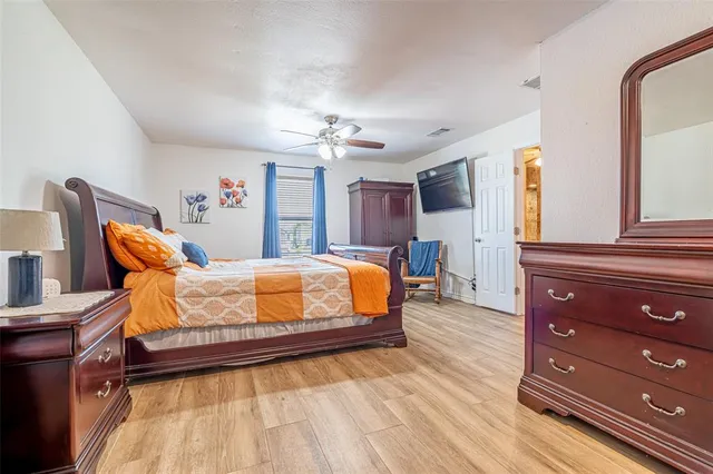 a bedroom with a bed and wooden floor