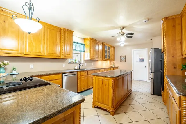 a kitchen with stainless steel appliances granite countertop a sink and a refrigerator