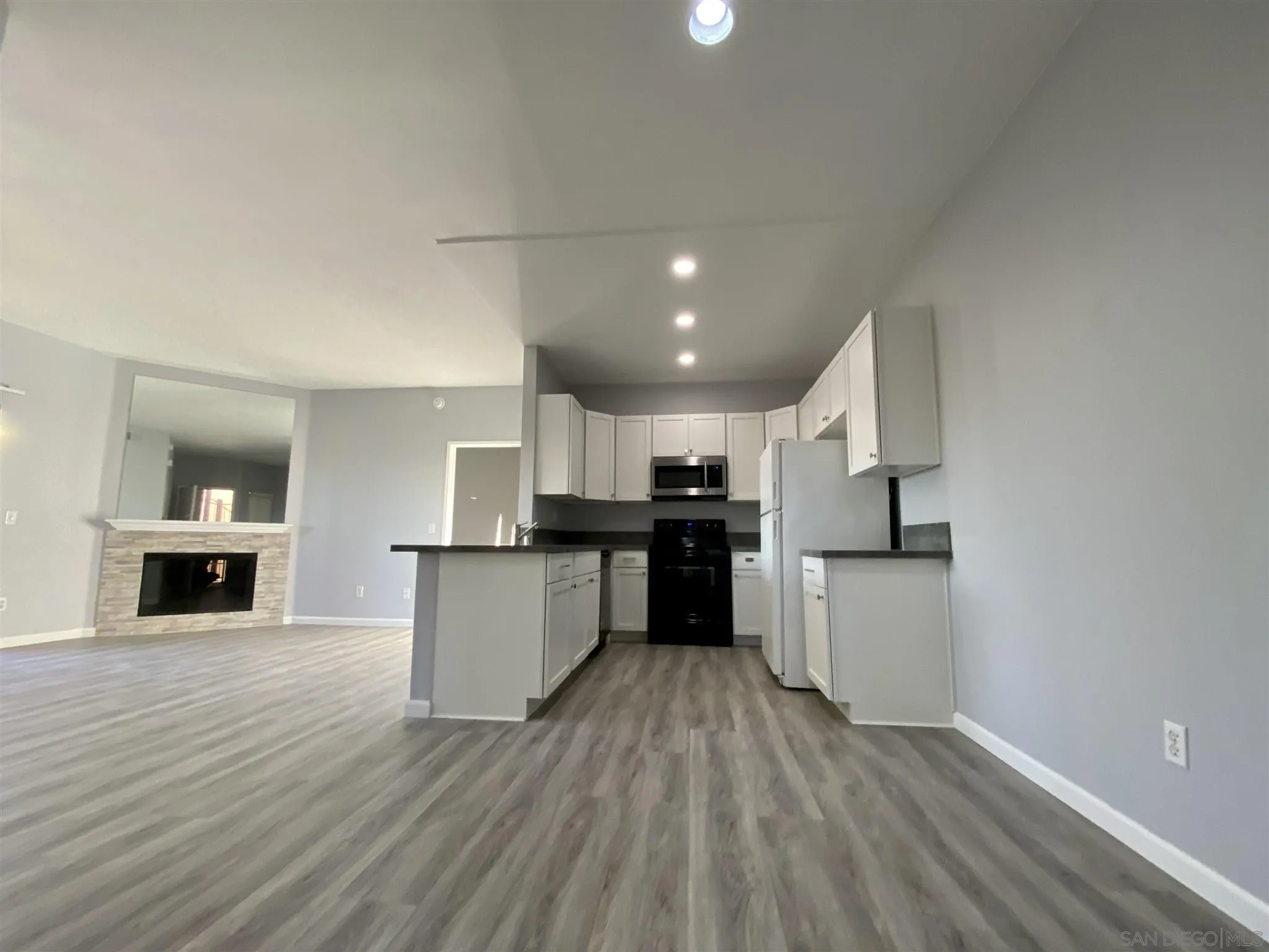 17161 Alva Road, Unit 213 San Diego, CA 92127 - Photo 17 of 48 a kitchen with kitchen island a counter top space a stove a sink and a refrigerator