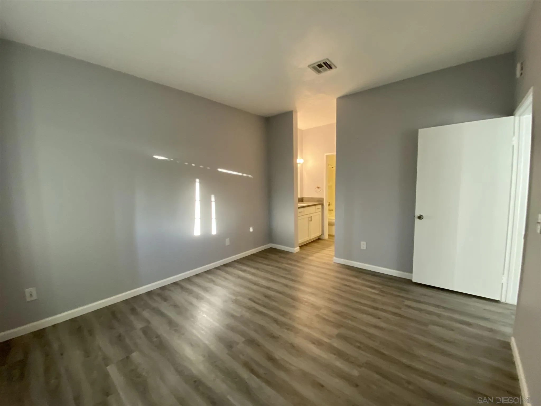 17161 Alva Road, Unit 213 San Diego, CA 92127 - Photo 27 of 48 a view of an empty room with wooden floor and a window