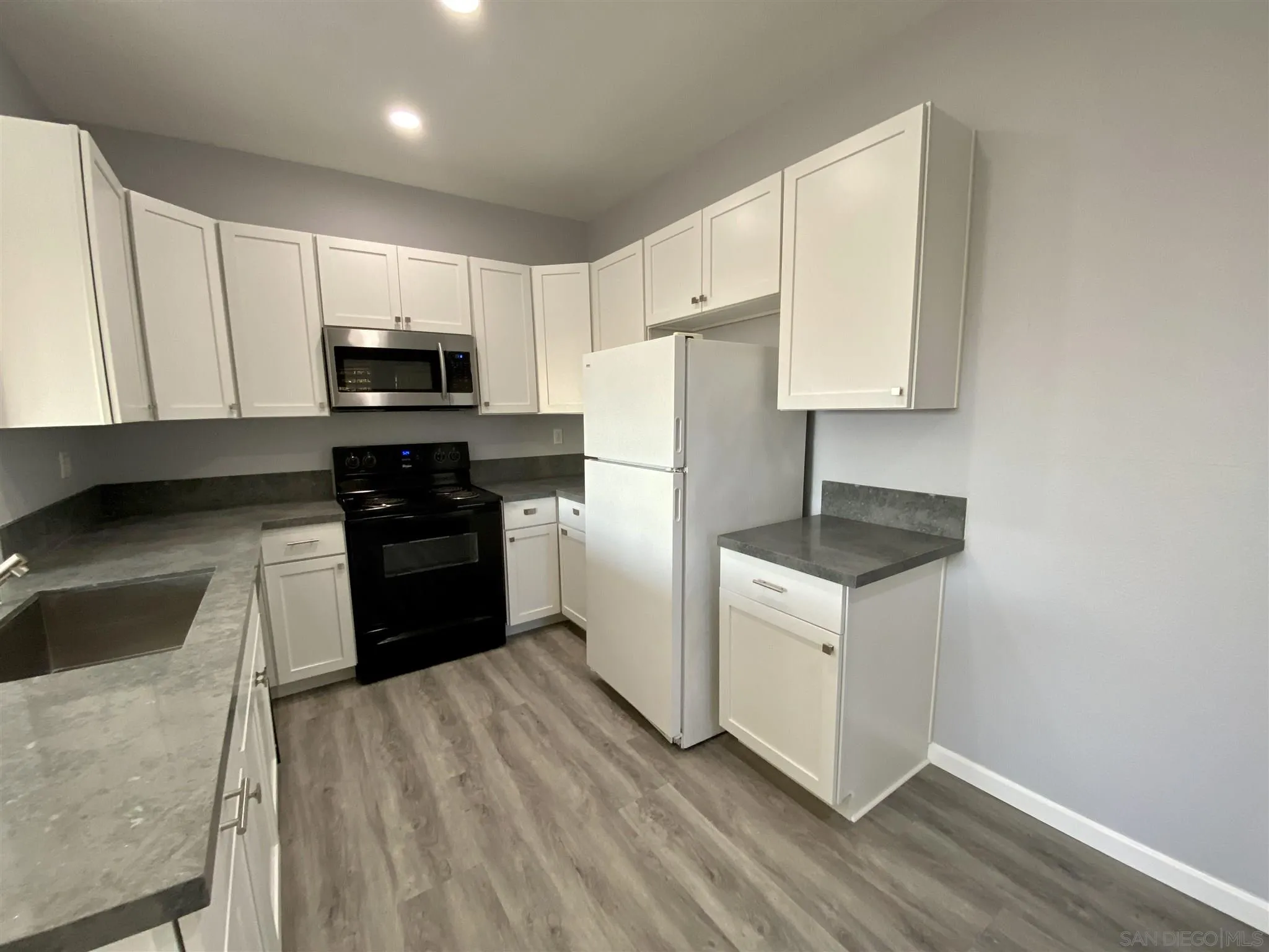 17161 Alva Road, Unit 213 San Diego, CA 92127 - Photo 3 of 48 a kitchen with a sink a stove a refrigerator and cabinets