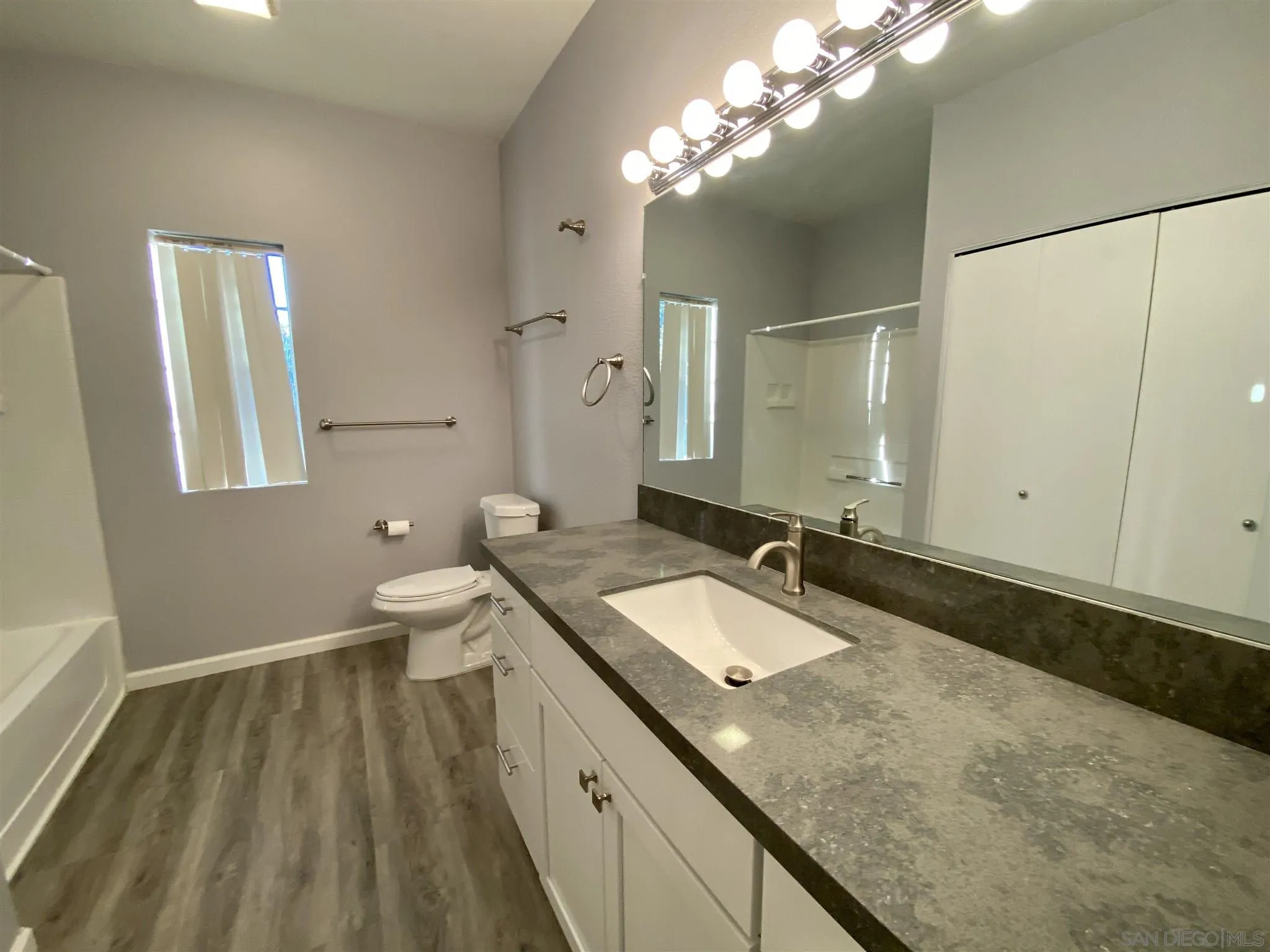 17161 Alva Road, Unit 213 San Diego, CA 92127 - Photo 4 of 48 a spacious bathroom with a granite countertop sink a toilet and a mirror