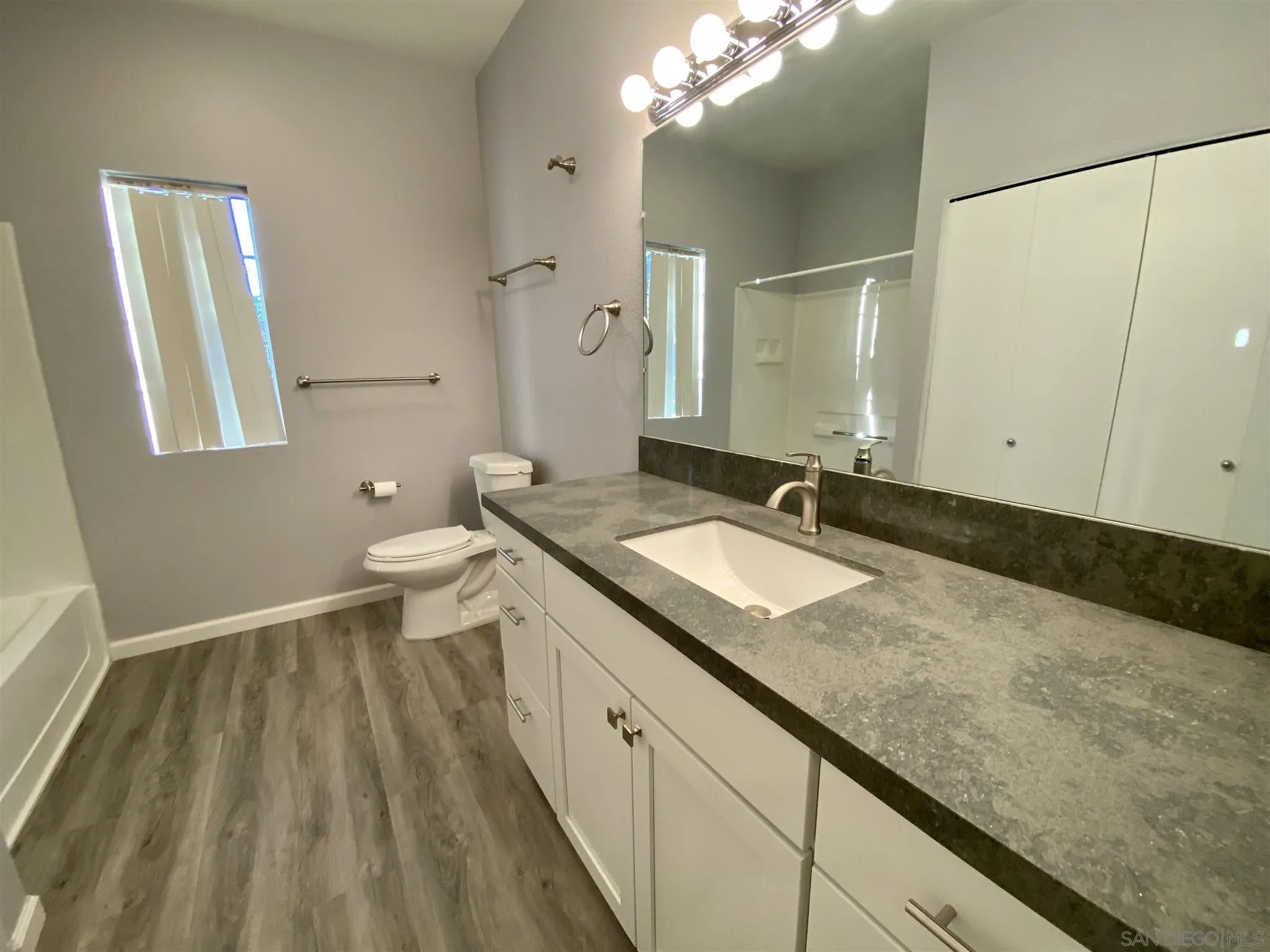 17161 Alva Road, Unit 213 San Diego, CA 92127 - Photo 7 of 48 a spacious bathroom with a granite countertop sink a toilet a mirror and shower
