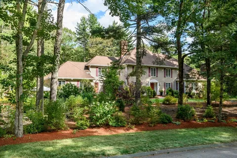 a view of a white house with a yard and plants