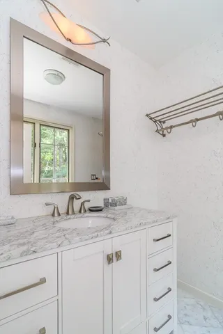 a bathroom with a granite countertop sink and a mirror