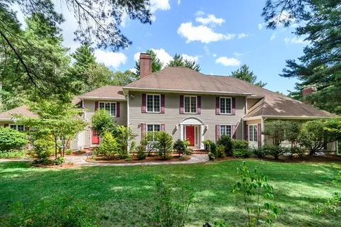 a front view of a house with a yard and potted plants