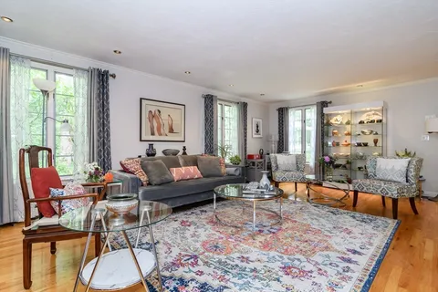 a living room with furniture large window and wooden floor