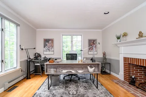 a workspace with furniture a fireplace and a window