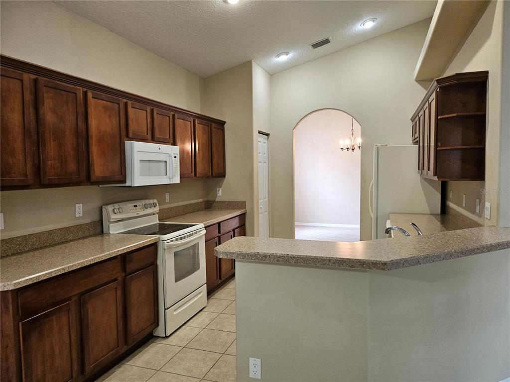 21 Raintree Circle Palm Coast, FL 32164 - Photo 3 of 10 a kitchen with stainless steel appliances granite countertop a stove a sink and a microwave