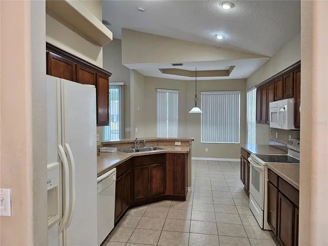 a large kitchen with stainless steel appliances granite countertop a refrigerator and a stove top oven