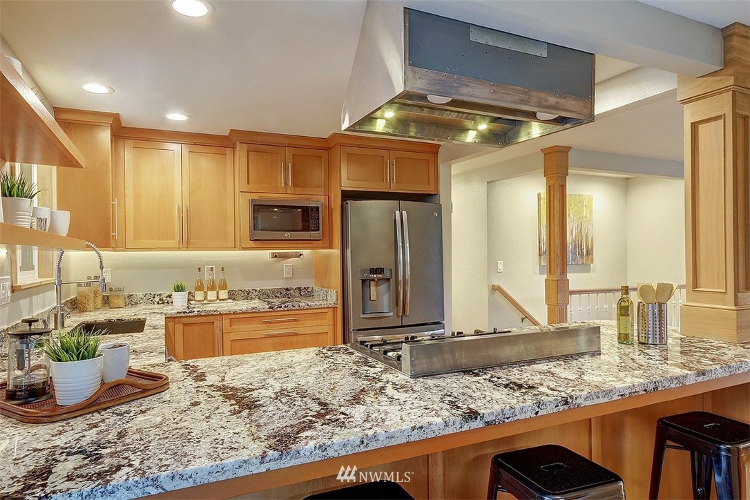 310 175th Place Southwest Bothell, WA 98012 - Photo 8 of 40 a view of a kitchen with kitchen island granite countertop a large counter top and stainless steel appliances