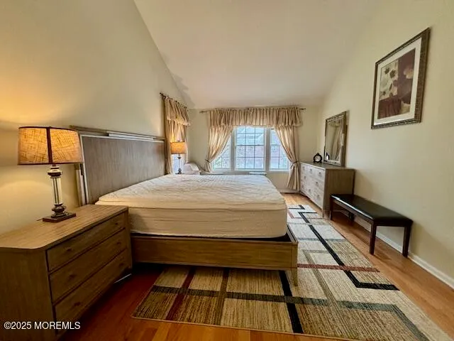 a bed room with a bed and a lamp on dresser