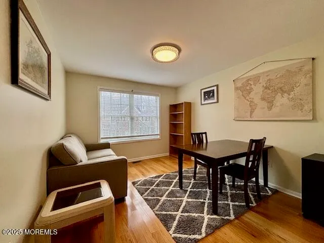 a living room with furniture a desk and chair with wooden floor