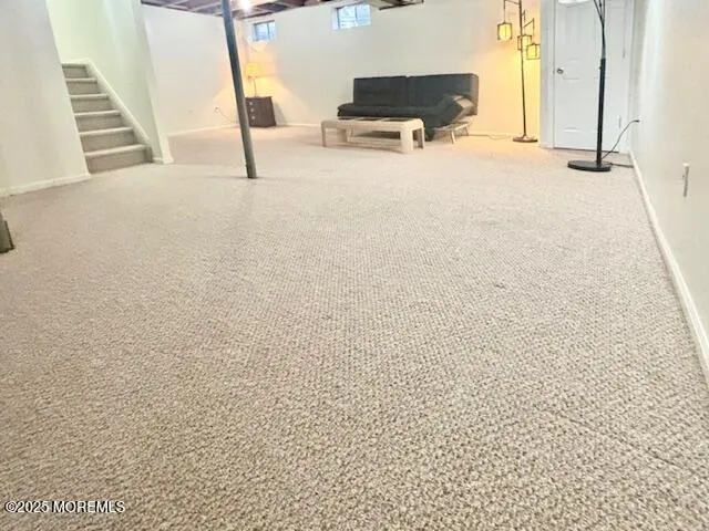 a view of kitchen and empty room with windows