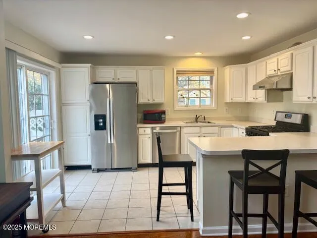 a kitchen with a sink a refrigerator and cabinets