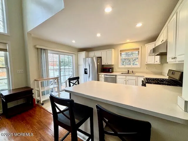 a large kitchen with sink a refrigerator and chairs