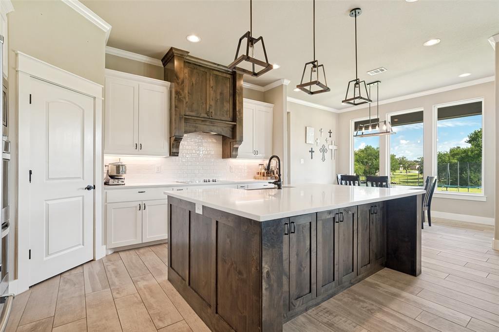 6913 Veal Station Road Weatherford, TX 76085 - Photo 7 of 31 Kitchen featuring an oversized island with a light-toned countertop, wood-finish flooring, white cabinetry, and a dark wood range hood