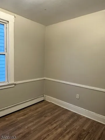 a view of a room with wooden floor and a window