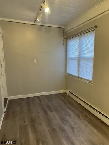 a view of a room with wooden floor and small window