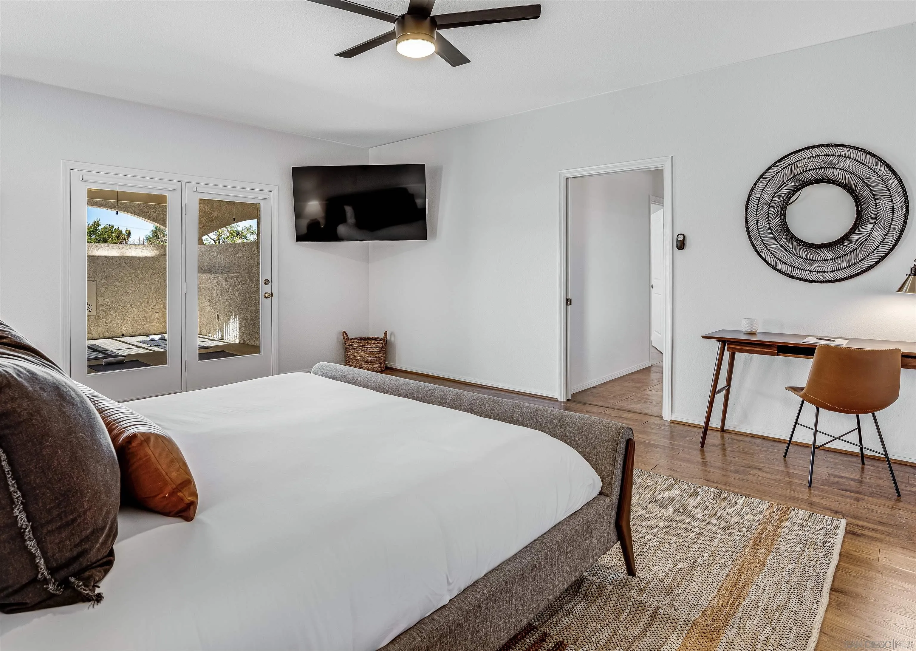 9255 Del Monte Avenue Yucca Valley, CA 92284 - Photo 17 of 46 a bedroom with a bed a mirror on dresser and a flat screen tv