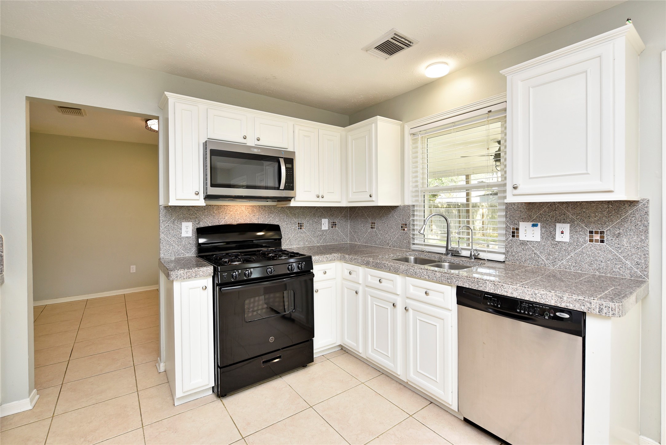 31106 Pine Bay Street Spring, TX 77386 - Photo 12 of 38 a kitchen with stainless steel appliances granite countertop a stove a sink and a microwave