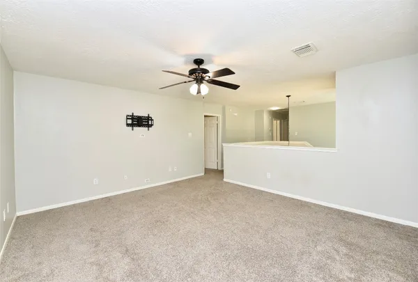 an empty room with a ceiling fan and a window