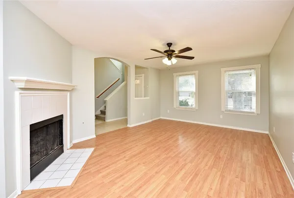 a view of an empty room with windows and a fireplace