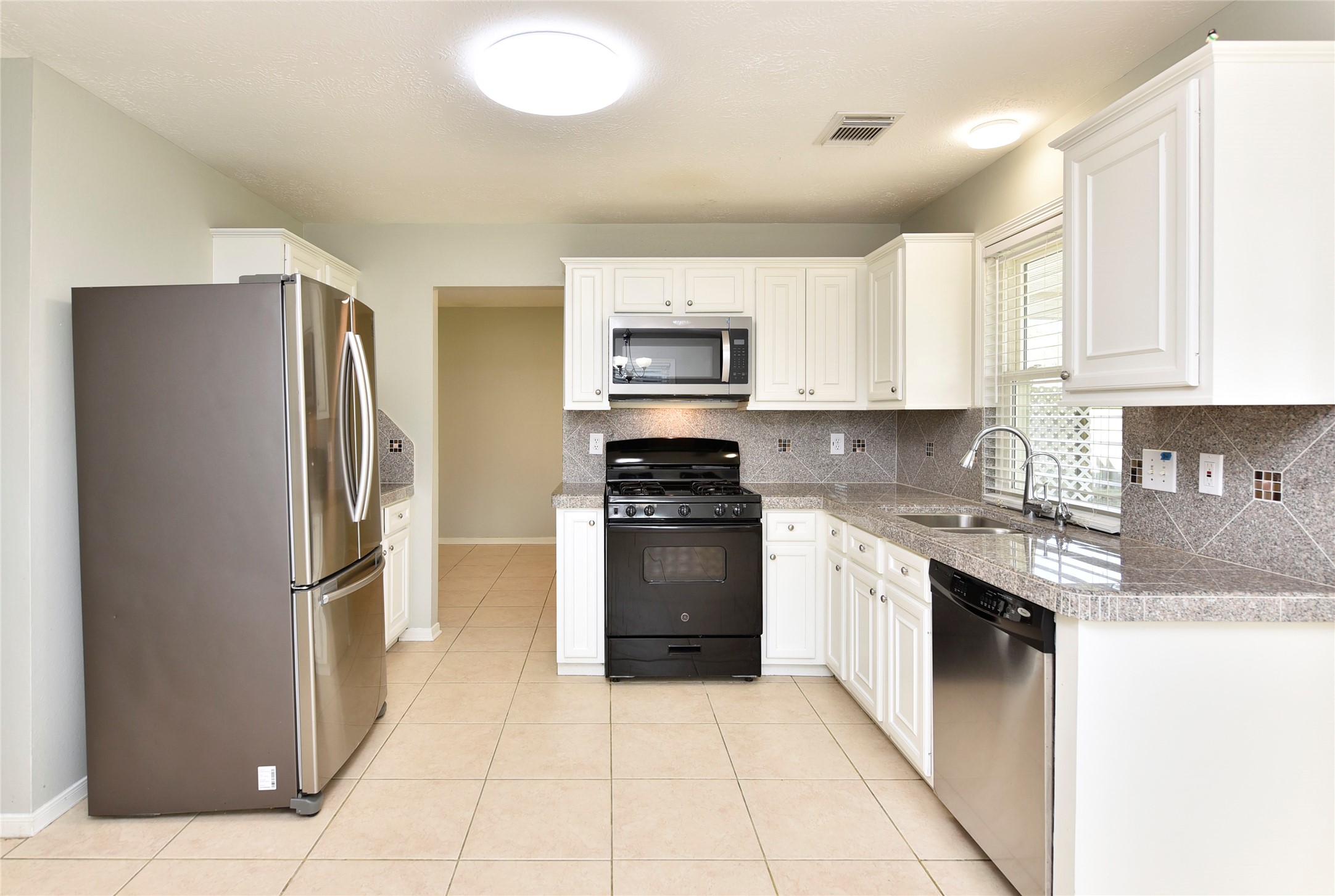 31106 Pine Bay Street Spring, TX 77386 - Photo 10 of 38 a kitchen with granite countertop a refrigerator and a stove top oven