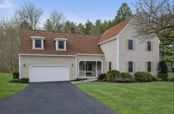 a front view of a house with a garden and yard