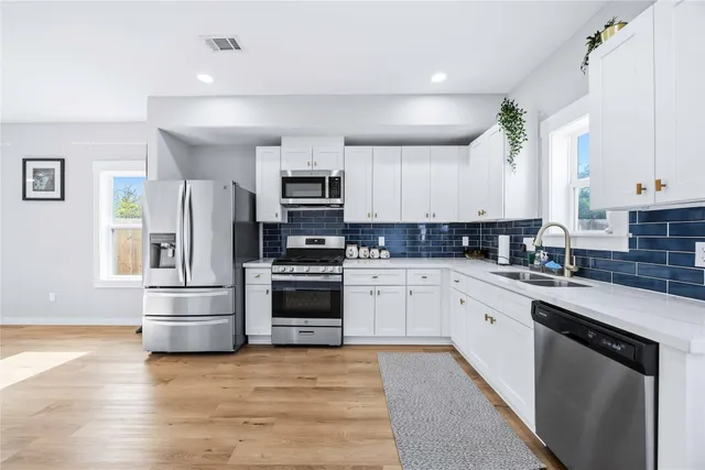 a kitchen with granite countertop a refrigerator stove and sink