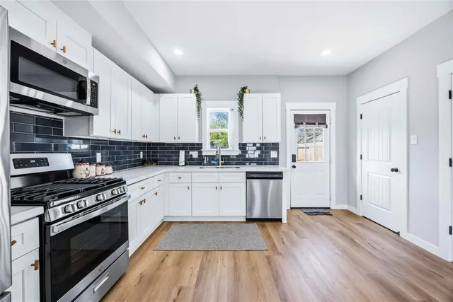 a kitchen with stainless steel appliances a white stove top oven and sink