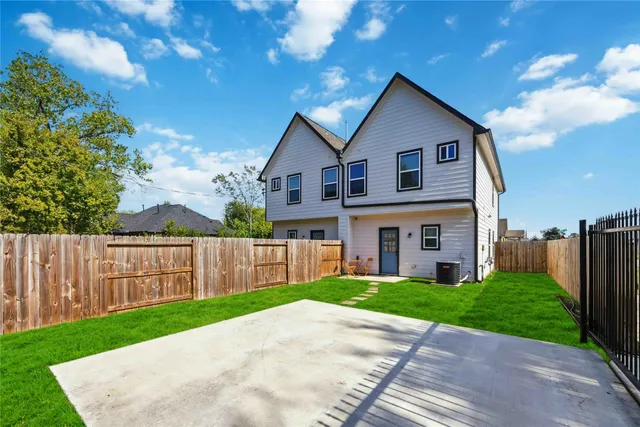 a view of a house with a big yard plants and large trees