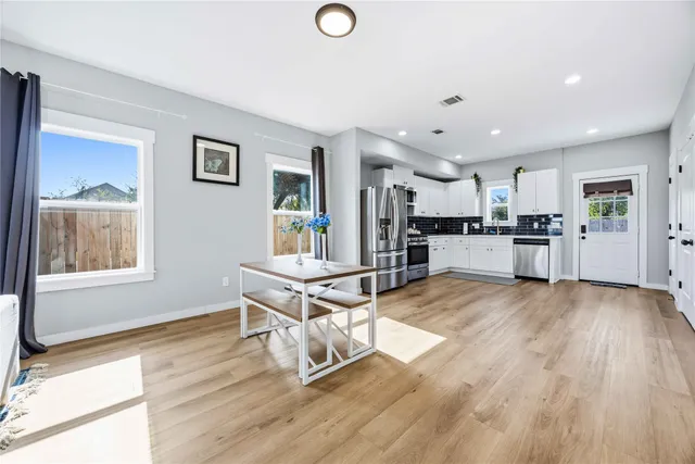 a living room with stainless steel appliances kitchen island granite countertop furniture and a wooden floor