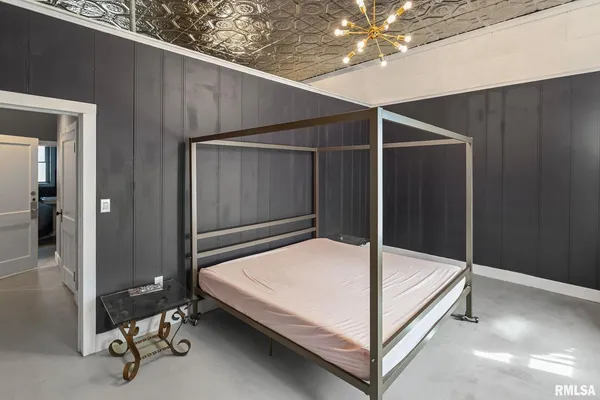 a bed room with a bed and a chandelier