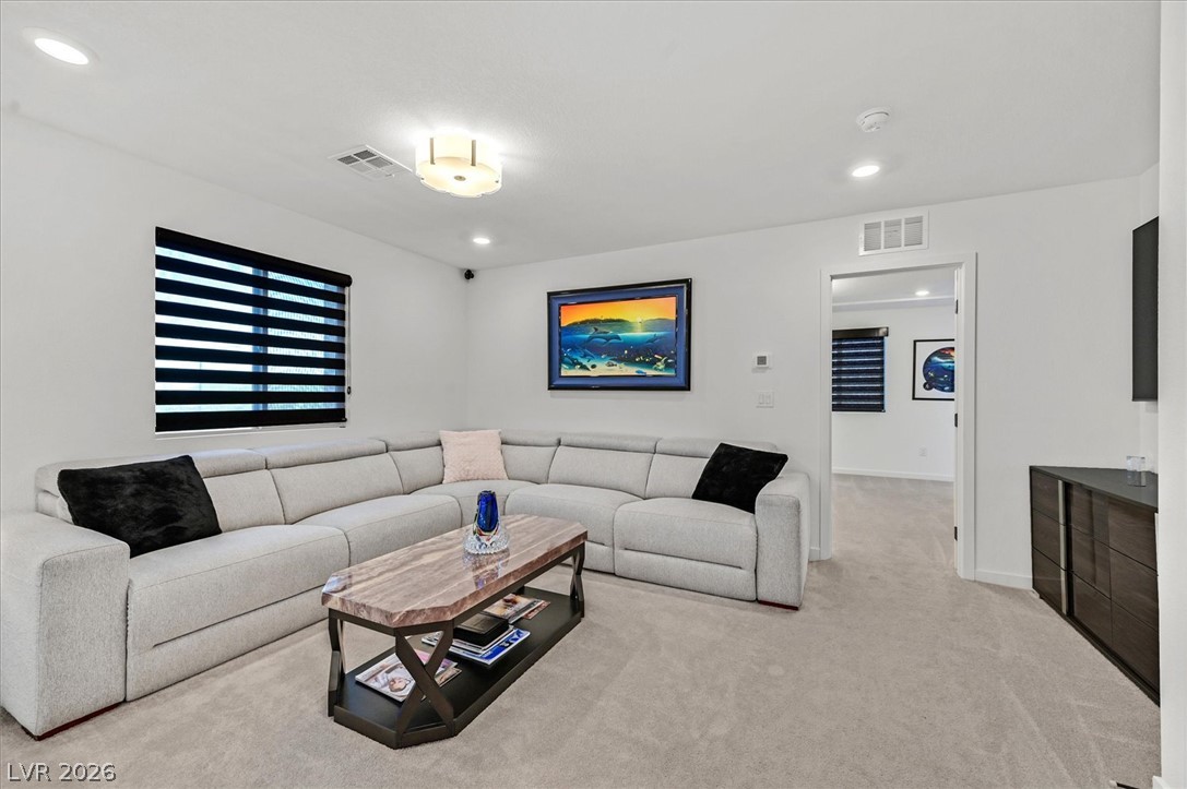 2933 Little Current Road North Las Vegas, NV 89086 - Photo 17 of 35 A comfortable living room features soft gray carpeting and a spacious sectional, perfect for relaxation.