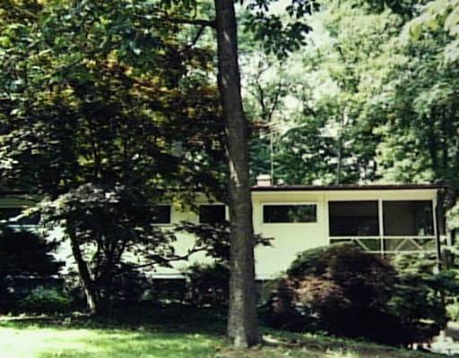 a front view of a house with a yard and potted plants