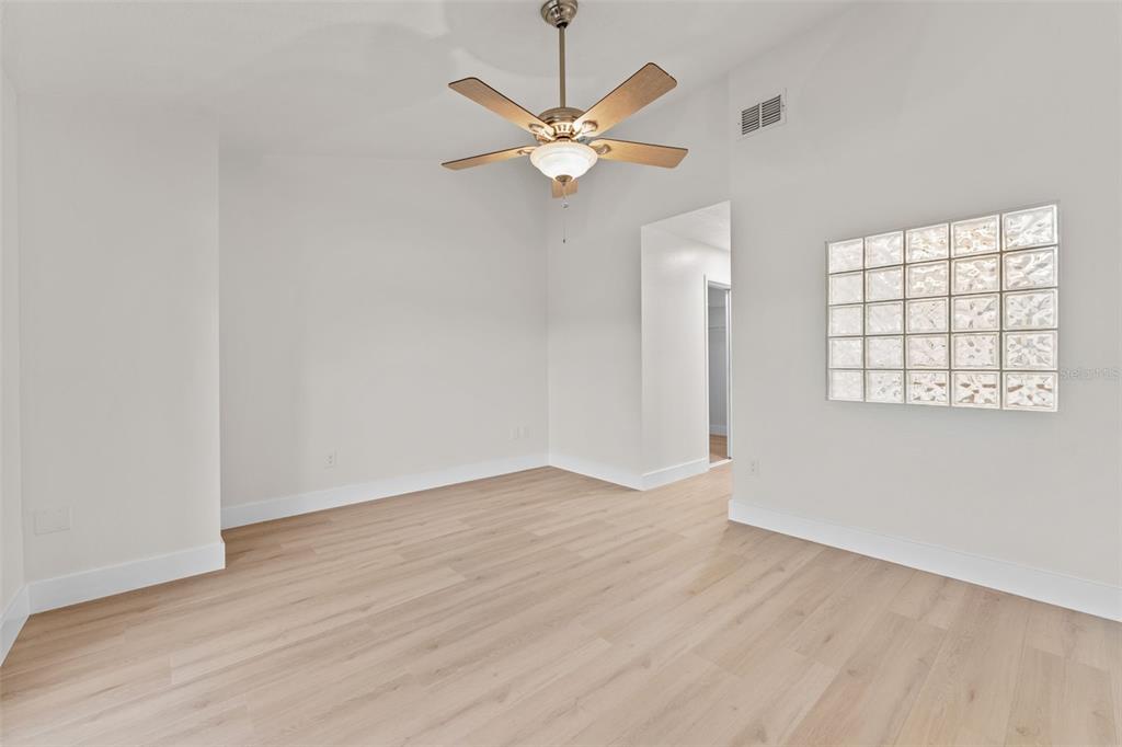 3058 Overlook Place Clearwater, FL 33760 - Photo 19 of 45 an empty room with wooden floor fan and windows