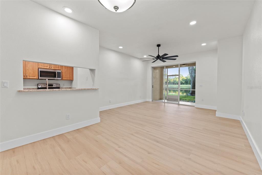3058 Overlook Place Clearwater, FL 33760 - Photo 8 of 45 a view of a livingroom with a flat screen tv wooden floor and a ceiling fan